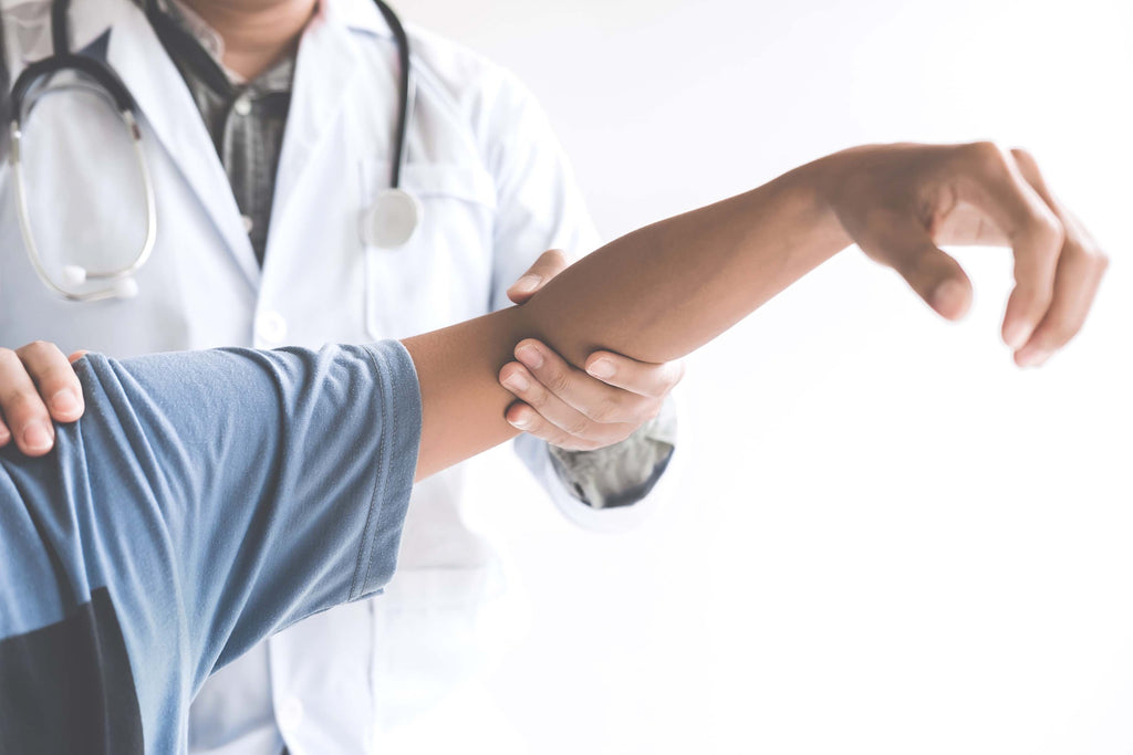 doctor checking patients elbow